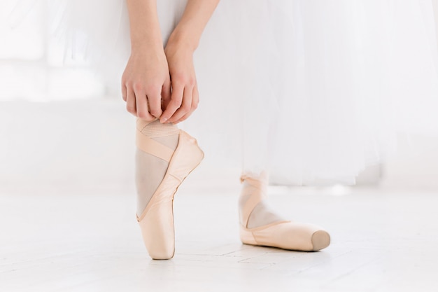 Giovane ballerina di danza, primo piano su gambe e scarpe, in piedi in posizione di punta.