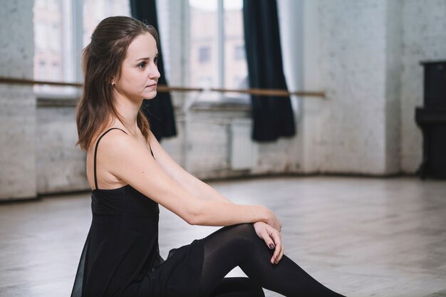 Giovane ballerina seduta sul pavimento