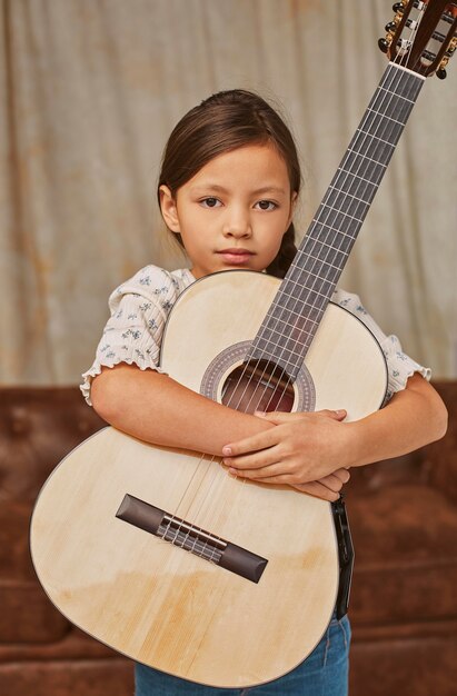 Giovane bambina a suonare la chitarra a casa