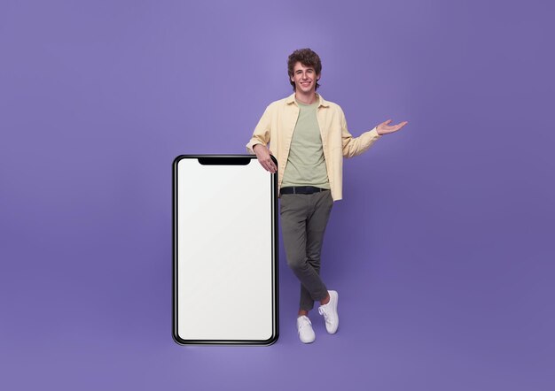 Giovane bell'uomo in piedi con mockup grande Smartphone bianco schermo bianco su sfondo viola