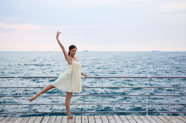 Giovane bella ballerina che balla e che posa fuori