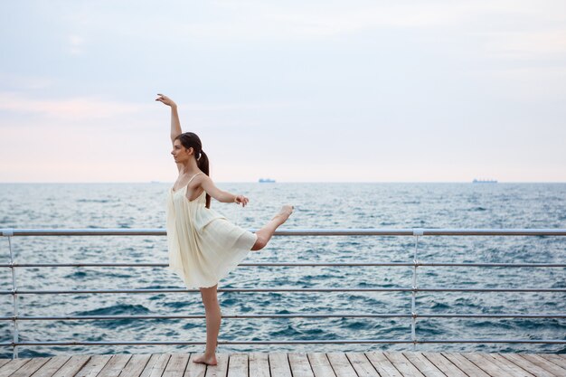 Giovane bella ballerina che balla e che posa fuori