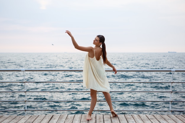 Giovane bella ballerina che balla e che posa fuori