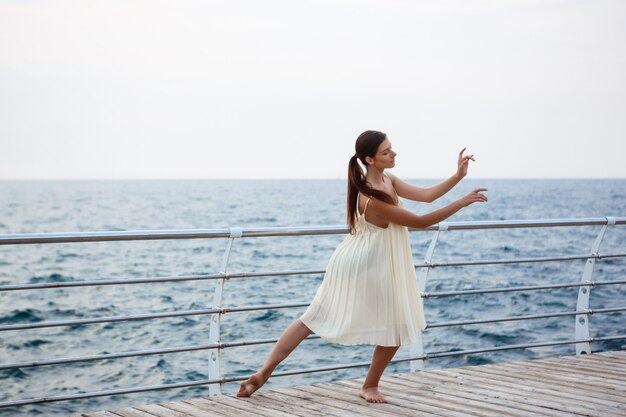 Giovane bella ballerina che balla e che posa fuori