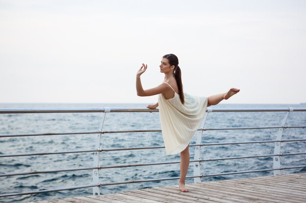 Giovane bella ballerina che balla e che posa fuori