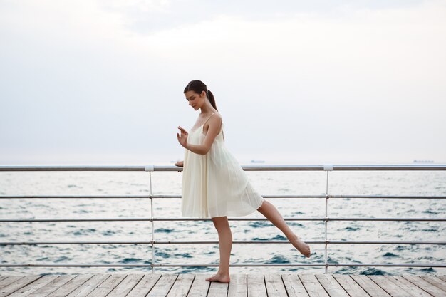 Giovane bella ballerina che balla e che posa fuori