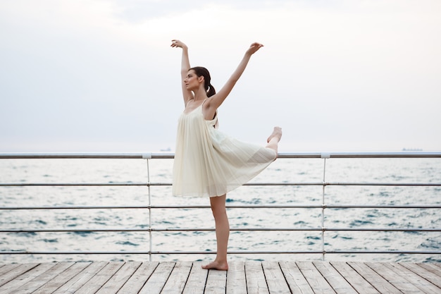 Giovane bella ballerina che balla e che posa fuori