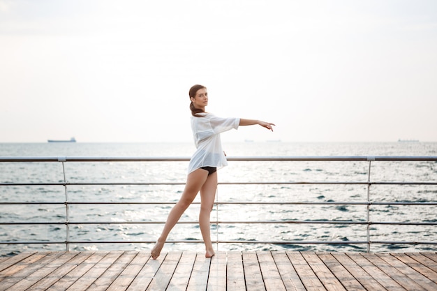 Giovane bella ballerina che balla e che posa fuori