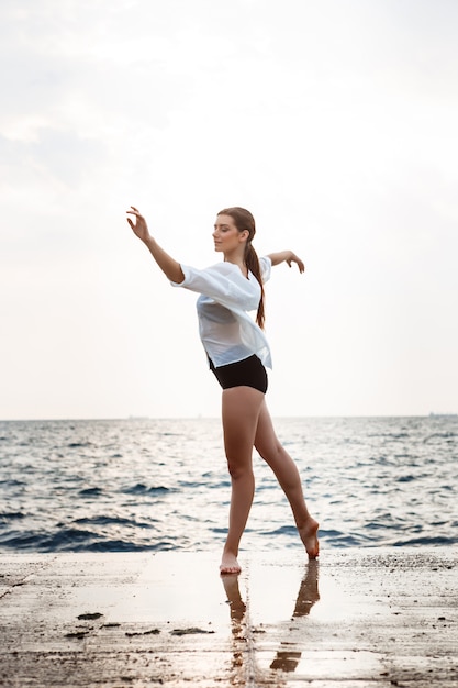 Giovane bella ballerina che balla e che posa fuori