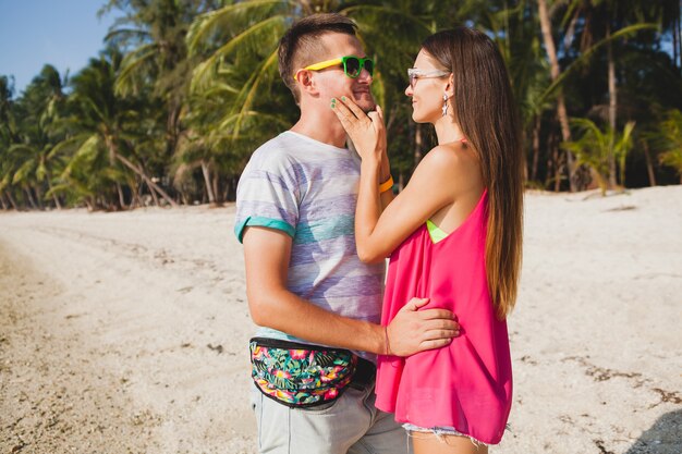 Giovane bella coppia che cammina sulla spiaggia tropicale, thailandia, abbracciare, ridere, occhiali da sole, divertirsi, abbigliamento hipster, stile casual, luna di miele, vacanza, estate, umore soleggiato e romantico