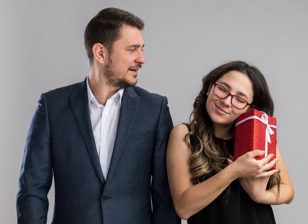 Giovane bella coppia felice uomo e donna con un regalo felice innamorato che celebra insieme il giorno di san valentino