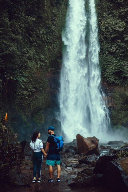 giovane bella coppia in posa sulla cascata, viaggiatori, escursionisti, zaini