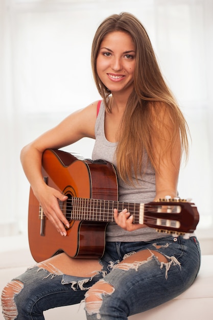 Giovane bella donna a suonare la chitarra