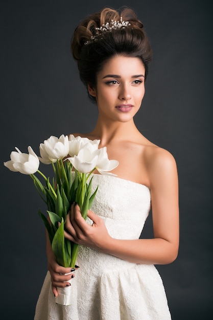 Giovane bella donna alla moda in abito da sposa