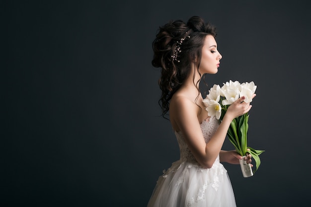 Giovane bella donna alla moda in abito da sposa