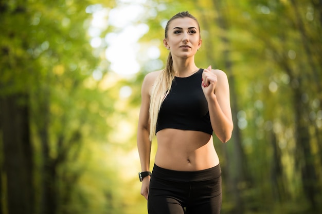 Giovane bella donna che fa jogging nel parco in estate