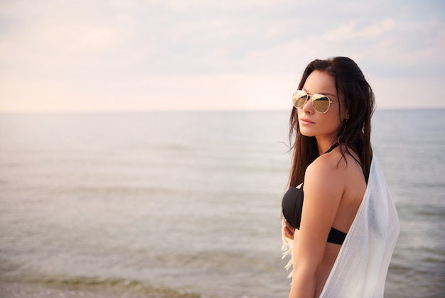 Giovane bella donna che ha divertimento sulla spiaggia