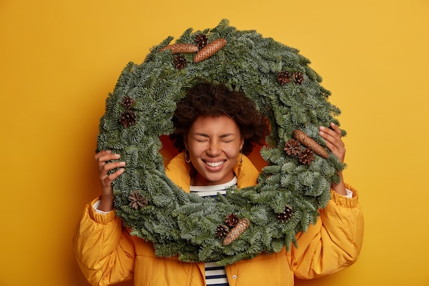 Giovane bella donna che tiene le decorazioni di Natale