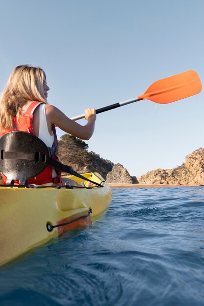 Giovane bella donna che viaggia in canoa