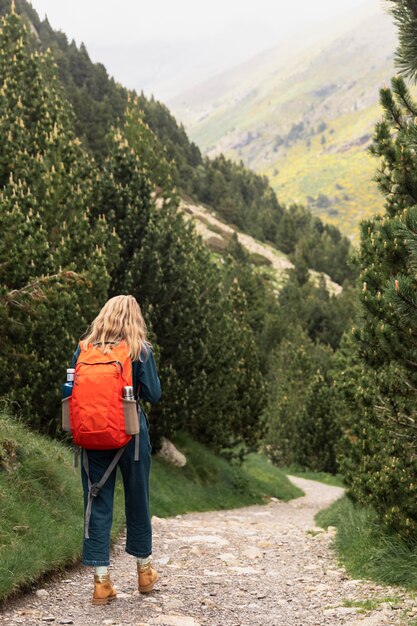 Giovane bella donna che viaggia in montagna