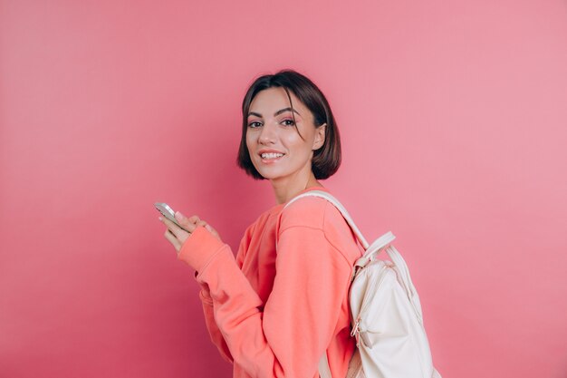 Giovane bella donna con lo smartphone. Ragazza sorridente dell'allievo che va su un viaggio.