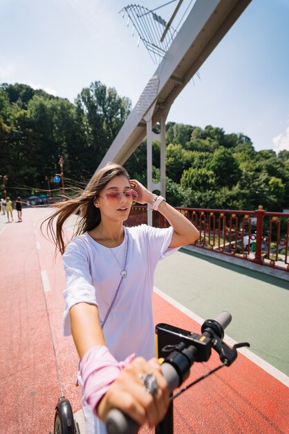 Giovane bella donna e un trasporto ecologico di scooter elettrico