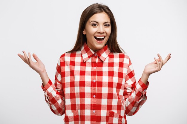 Giovane bella donna in camicia a quadri bianca e rossa