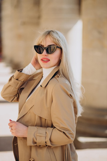 Giovane bella donna in cappotto beige