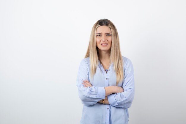 giovane bella donna in piedi sul muro bianco.