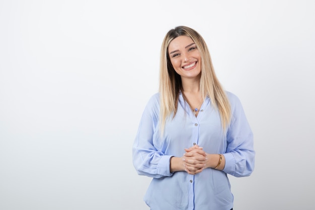 giovane bella donna in piedi sul muro bianco.