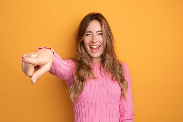 Giovane bella donna in top rosa che guarda l'obbiettivo sorridente felice ed eccitato