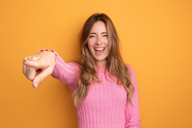 Giovane bella donna in top rosa che guarda l'obbiettivo sorridente felice ed eccitato