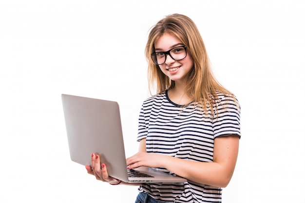 Giovane bella donna moderna con un computer portatile in mano, appoggiandosi su un muro bianco