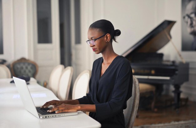 giovane bella donna nera lavora con un computer