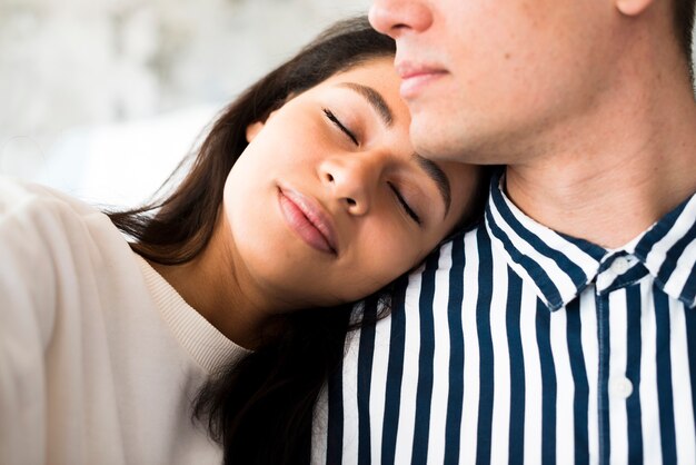 Giovane bella femmina che si appoggia sulla spalla di fidanzati