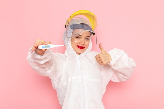 giovane bella femmina in abito bianco speciale che indossa il dispositivo di tenuta del casco protettivo in rosa