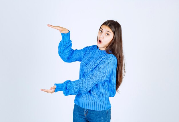 Giovane bella ragazza che gesturing con le mani che mostrano il segno di grandi e grandi dimensioni.