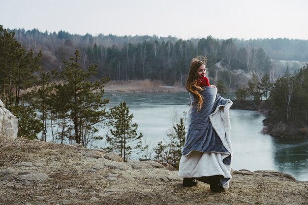 Giovane bella ragazza che posa su un lago