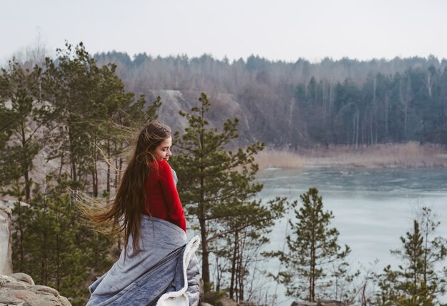 Giovane bella ragazza che posa su un lago