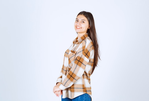 giovane bella ragazza in abito casual in posa sul muro bianco.