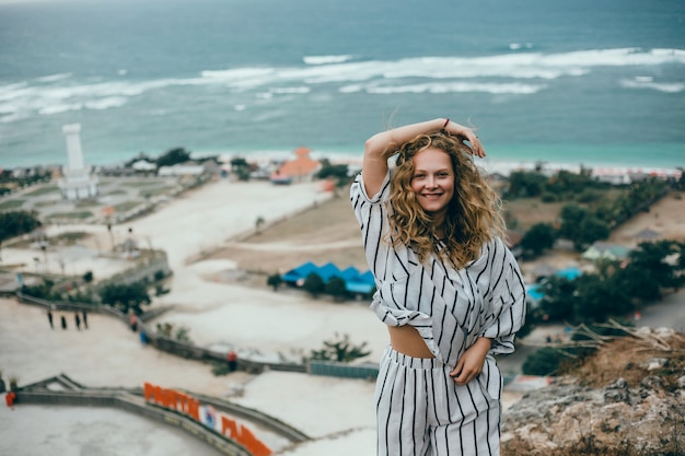 giovane bella ragazza in posa sulla spiaggia, oceano, onde, sole splendente e pelle abbronzata