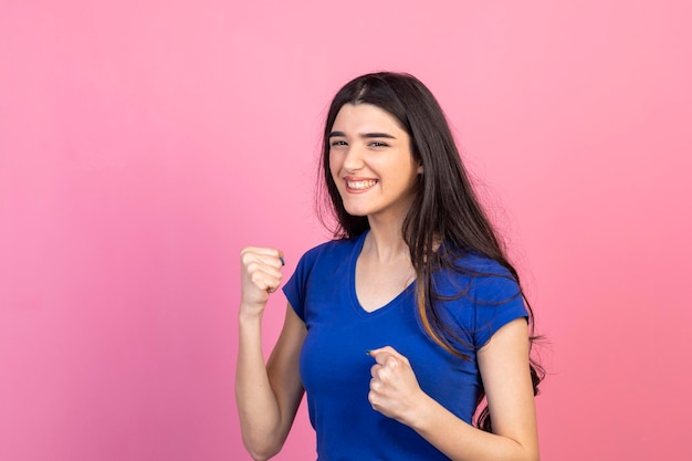 Giovane bella ragazza motivata stringere i pugni e sorridere Foto di alta qualità