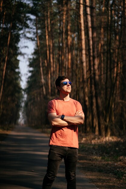 Giovane bello all'aperto nel parco, camminando nel parco