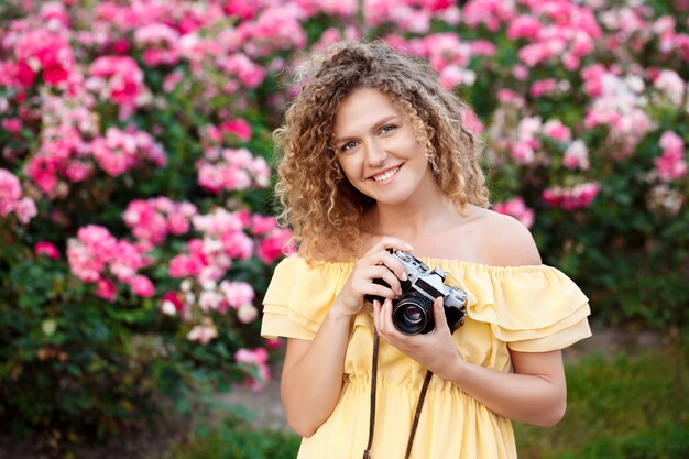 Giovane bello fotografo che cammina intorno alla città.