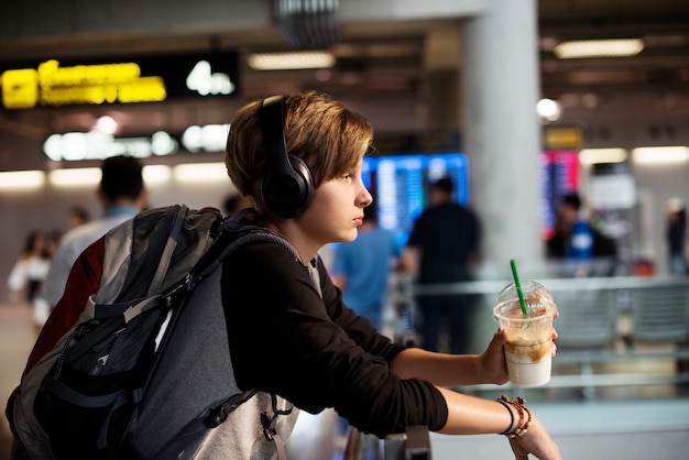 Giovane bevanda caucasica della bevanda della tenuta del viaggiatore nell&#39;aeroporto