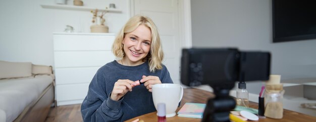 Giovane blogger di bellezza carismatica adolescente registra un video di lei che si applica la mascara e rivede il trucco