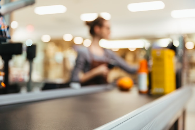 Foto gratuito giovane cassiere femmina scansione articoli alimentari