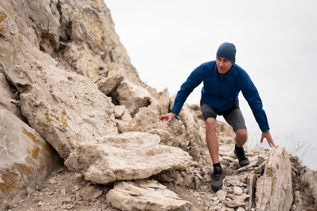 Giovane che cammina attraverso le rocce in natura