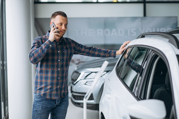 Giovane che compra un'automobile in una sala d'esposizione dell'automobile