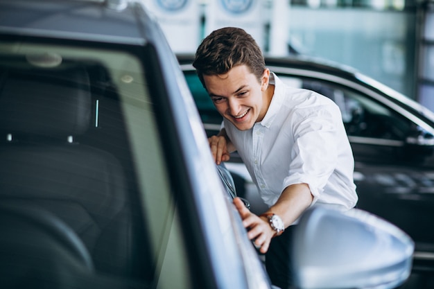 Giovane che compra un'automobile in uno showroom